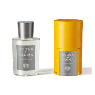 Frasco de perfume ‘ACQUA DI PARMA COLONIA PURA’ transparente com tampa prateada ao lado da embalagem amarela.
