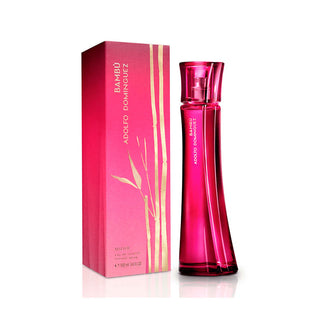 Frasco de perfume ‘BAMBU ADOLFO DOMINGUEZ’ rosa com ilustrações douradas de bambu ao lado da sua caixa de embalagem.