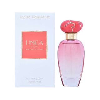 Frasco de perfume ‘UNICA’ da ADOLFO DOMINGUEZ, com líquido rosa e tampa artística, ao lado da sua caixa de embalagem branca com padrões florais.